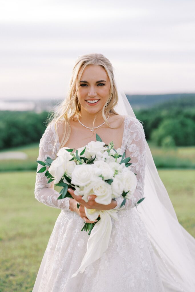 bride holding her all white bouquet, looking at the camera for her Lakeview Hills Wedding