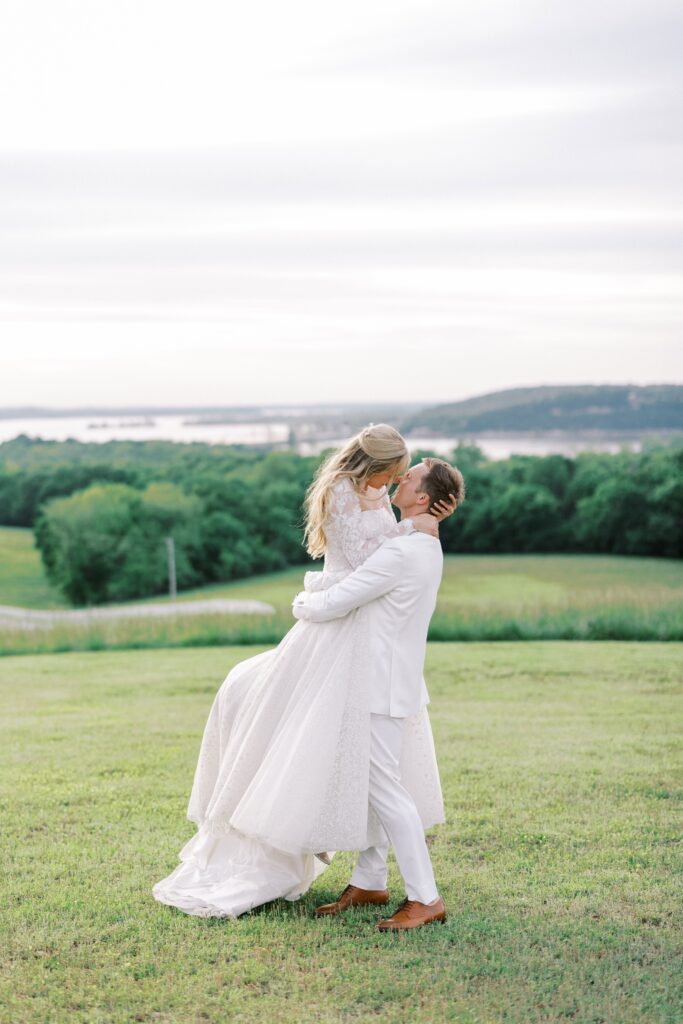 groom picking up his bride and kissing her at their Lakeview Hills Wedding