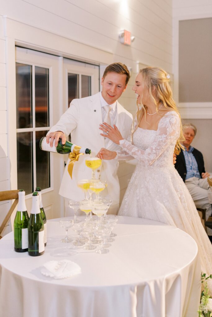 bride and groom pouring champagne on their champagne tower a their Lakeview Hills Wedding