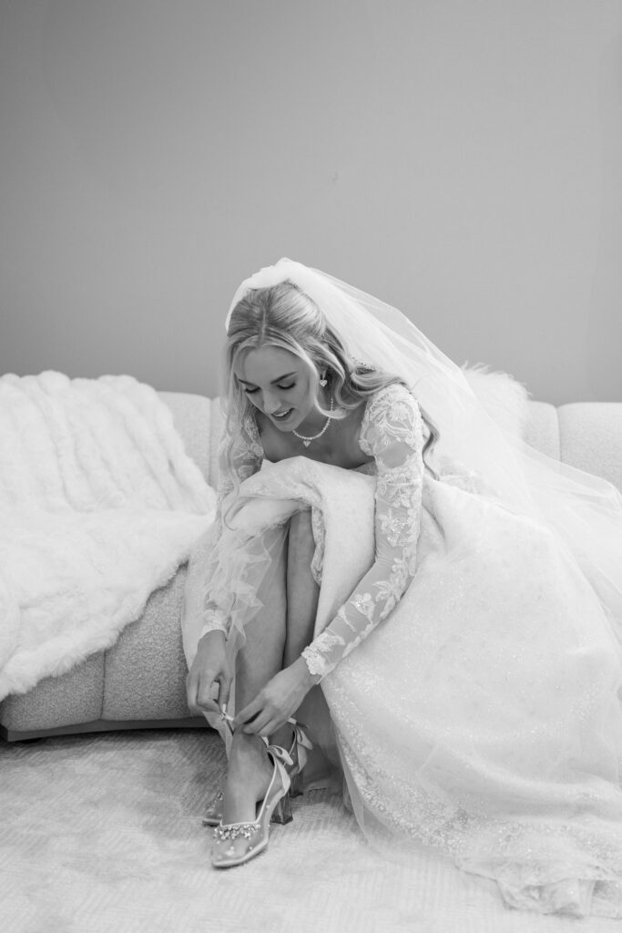 black and white of bride putting on her shoes at her Lakeview Hills Wedding