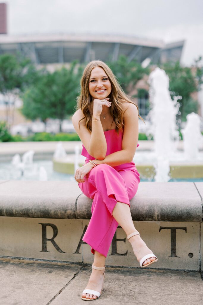 taylor sitting on the fountain in front of kyle fields, senior portrait locations