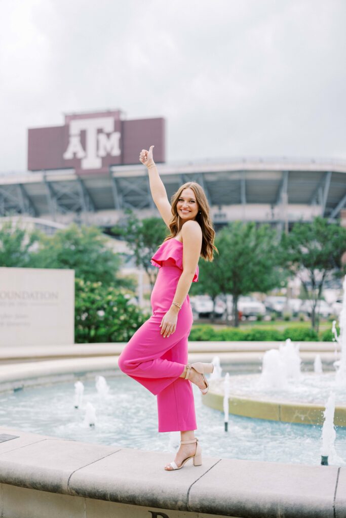 taylor doing a gig em on the fountain in front of a senior portrait locations